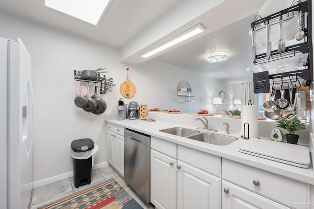 14259 Perdido Key Dr Unit 1C, Pensacola, FL 32507 - kitchen with light tile patterned floors, white fridge with ice dispenser, white cabinetry, stainless steel dishwasher, and a sink