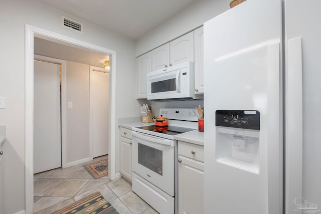 14259 Perdido Key Dr Unit 1C, Pensacola, FL 32507 - kitchen featuring white appliances, light tile patterned floors, light countertops, white cabinetry, and visible vents
