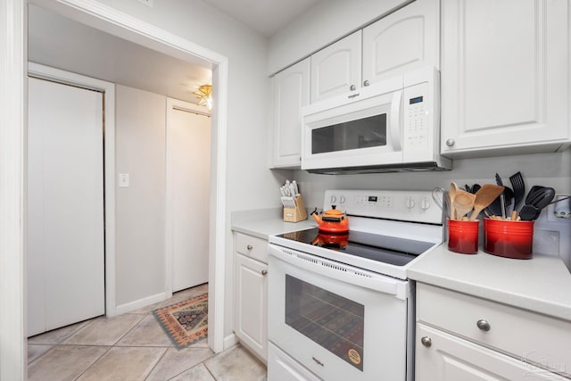 14259 Perdido Key Dr Unit 1C, Pensacola, FL 32507 - kitchen featuring baseboards, white appliances, light countertops, white cabinetry, and light tile patterned flooring