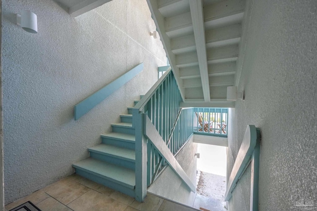 14259 Perdido Key Dr Unit 1C, Pensacola, FL 32507 - staircase featuring a towering ceiling, tile patterned flooring, and a textured wall