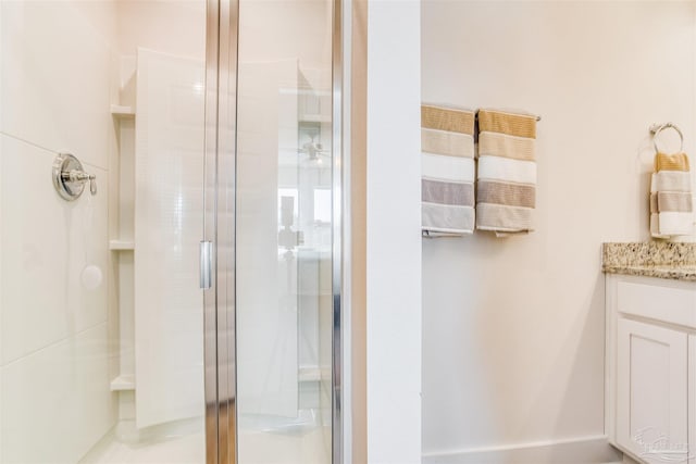 bathroom featuring walk in shower and vanity