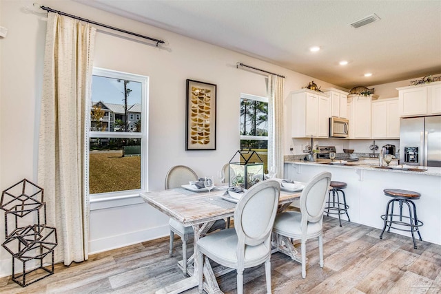 dining space with light hardwood / wood-style flooring