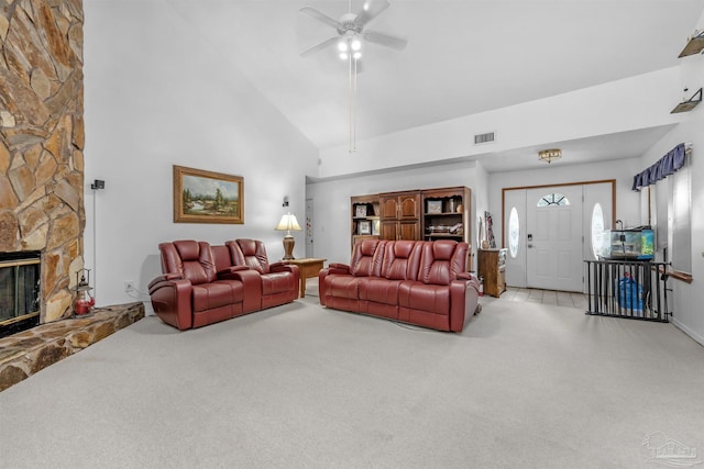 carpeted living room featuring ceiling fan, high vaulted ceiling, and a stone fireplace