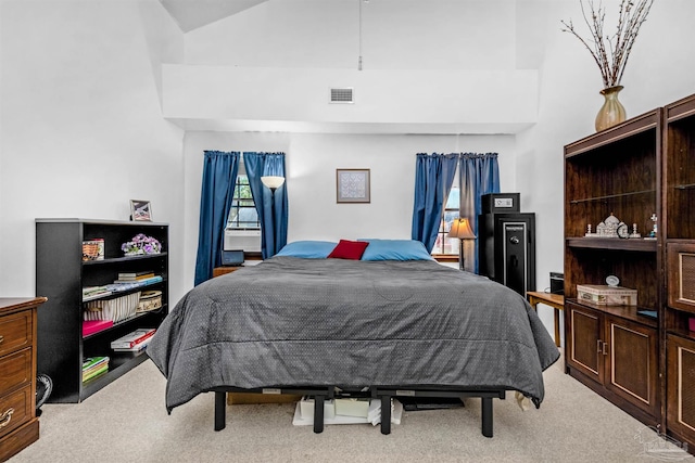 bedroom featuring light carpet and high vaulted ceiling