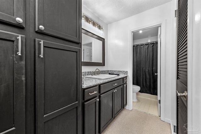 bathroom featuring toilet, tile patterned flooring, vanity, a textured ceiling, and walk in shower