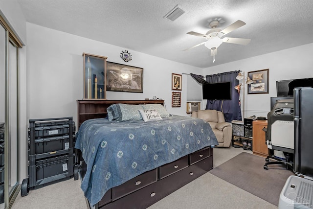 carpeted bedroom featuring a closet, a textured ceiling, and ceiling fan