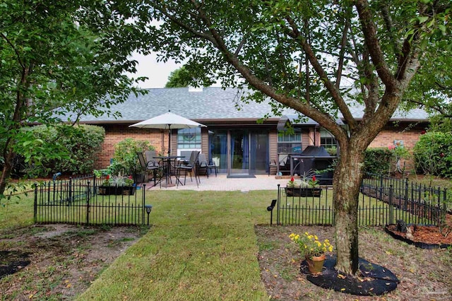 back of property with a yard and a patio