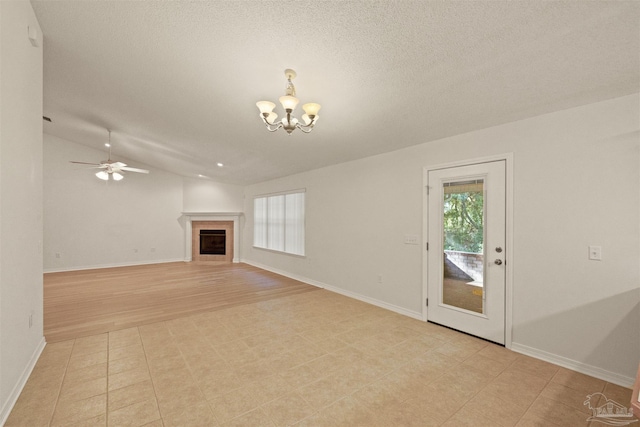 unfurnished living room with light wood-type flooring, ceiling fan with notable chandelier, a textured ceiling, lofted ceiling, and a tiled fireplace