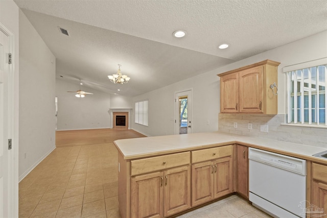 kitchen with kitchen peninsula, ceiling fan with notable chandelier, white dishwasher, light tile patterned floors, and lofted ceiling