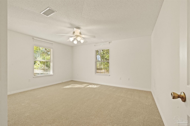 carpeted empty room with ceiling fan and a textured ceiling