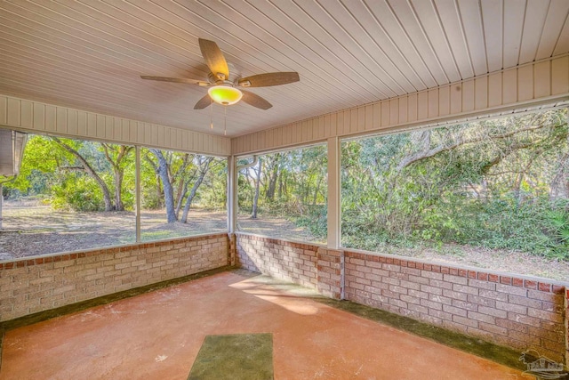 unfurnished sunroom with ceiling fan, wood ceiling, and a wealth of natural light