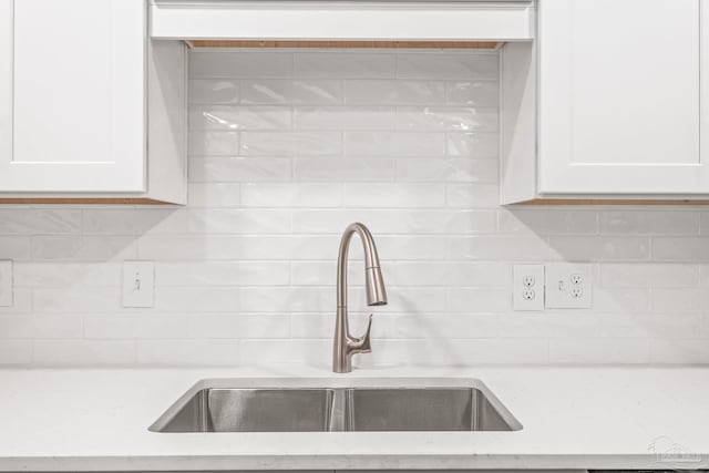 kitchen with white cabinets, backsplash, and sink