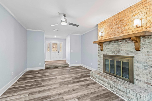 unfurnished living room featuring hardwood / wood-style floors, ceiling fan, ornamental molding, and a fireplace