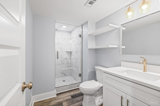 bathroom with hardwood / wood-style flooring, vanity, toilet, and a shower with shower door