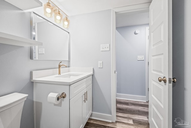 bathroom with hardwood / wood-style floors, vanity, and toilet