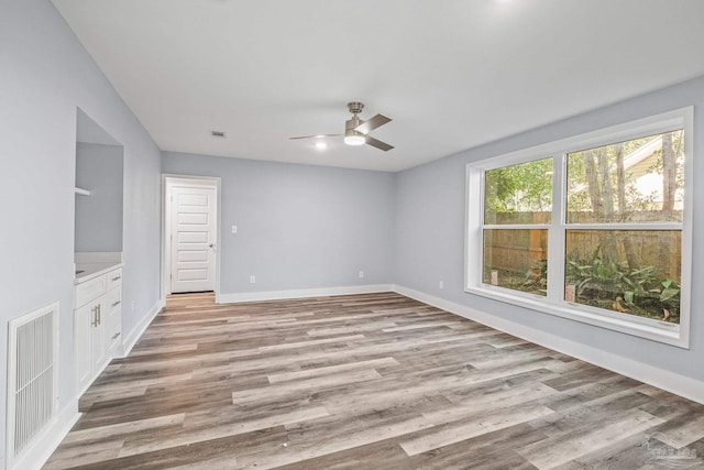 empty room with ceiling fan and light wood-type flooring