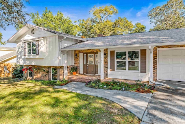 split level home featuring a porch, a garage, and a front lawn