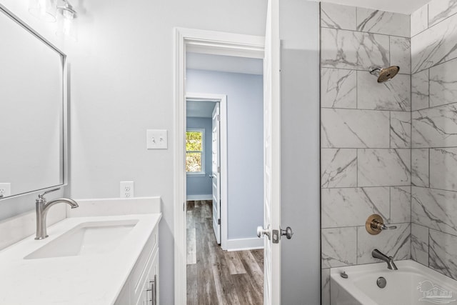 bathroom featuring hardwood / wood-style floors, vanity, and tiled shower / bath