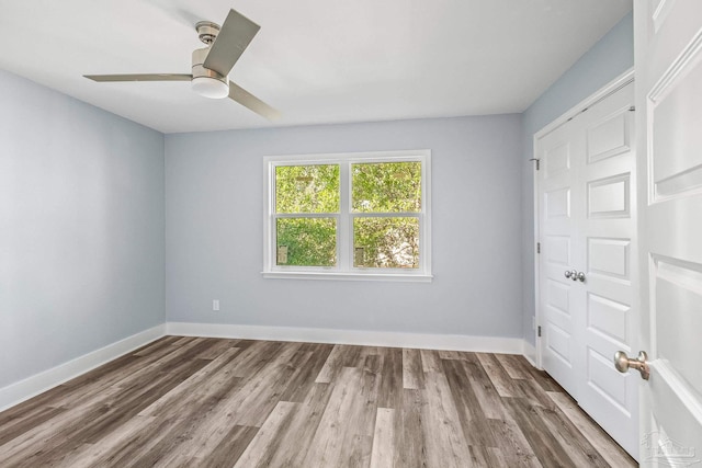 unfurnished bedroom featuring a closet, ceiling fan, and dark wood-type flooring