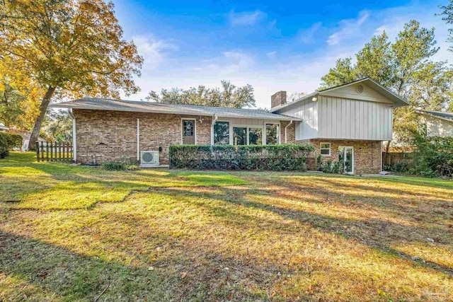 back of property with a yard and ac unit