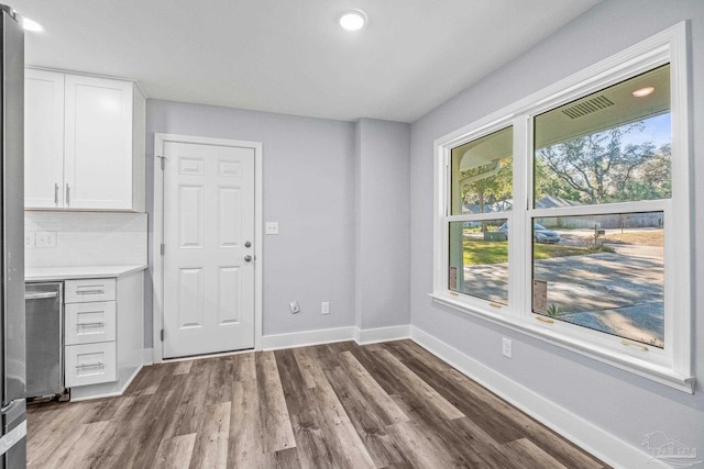 unfurnished dining area featuring dark wood-type flooring