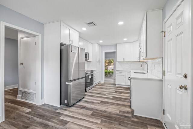 kitchen featuring white cabinets, sink, dark wood-type flooring, and appliances with stainless steel finishes