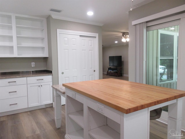 dining area with crown molding, ceiling fan, and light hardwood / wood-style flooring