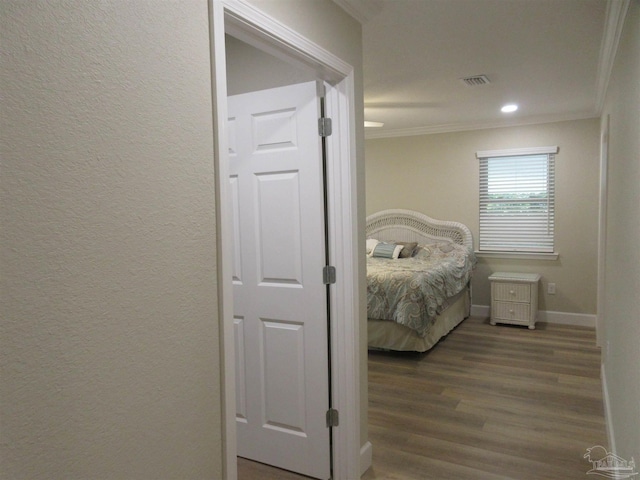 bedroom with crown molding and dark hardwood / wood-style flooring