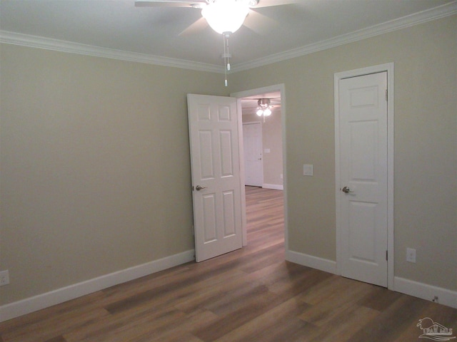 unfurnished room with ceiling fan, dark wood-type flooring, and crown molding