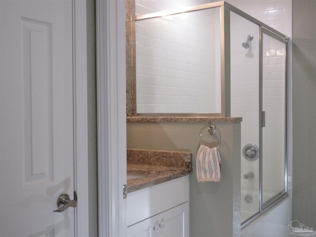 bathroom featuring vanity and combined bath / shower with glass door