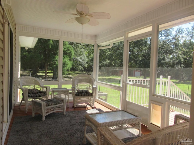 sunroom featuring ceiling fan and plenty of natural light