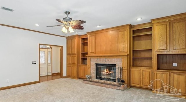 unfurnished living room featuring ceiling fan, ornamental molding, light carpet, and a brick fireplace