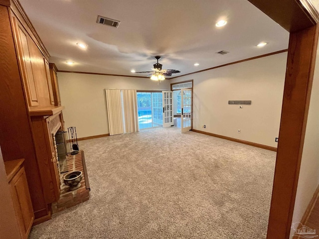 unfurnished living room featuring ceiling fan, ornamental molding, a fireplace, and light carpet