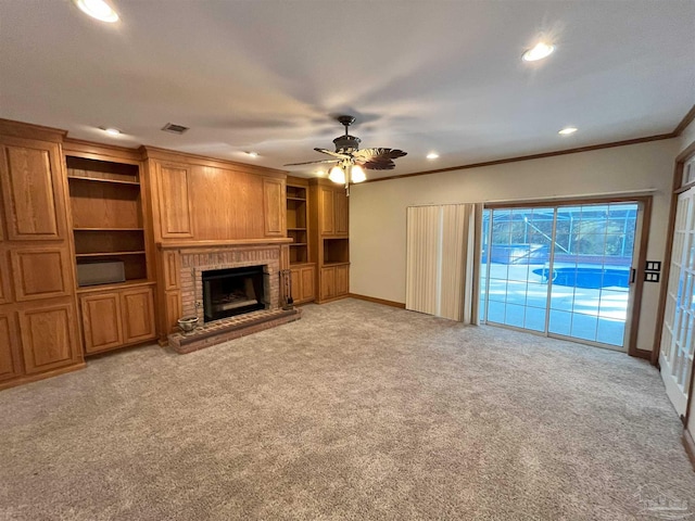 unfurnished living room with ceiling fan, crown molding, a fireplace, and light carpet