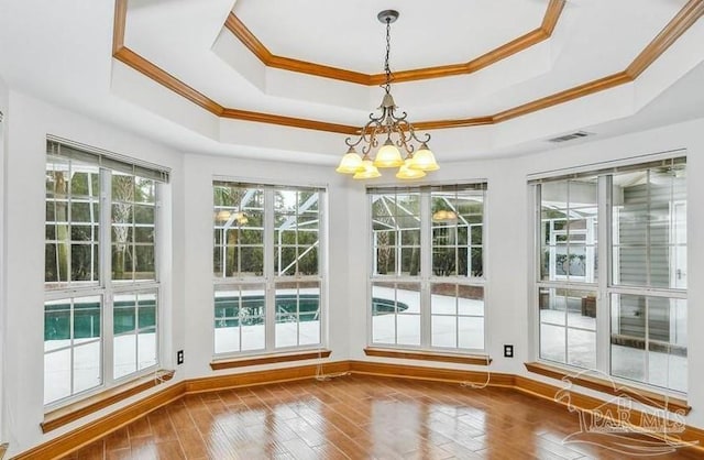 unfurnished sunroom with a tray ceiling and a notable chandelier