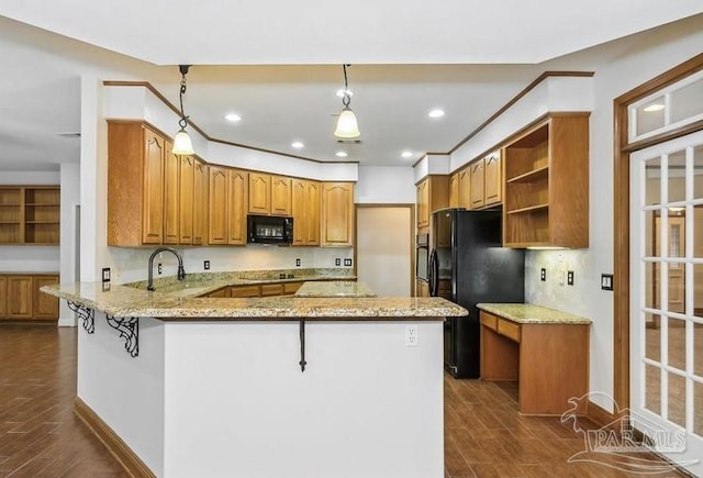 kitchen with light stone countertops, dark wood-type flooring, kitchen peninsula, pendant lighting, and black appliances