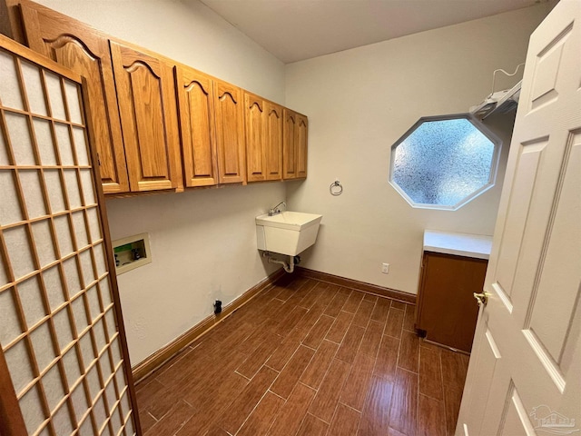 laundry room featuring dark hardwood / wood-style floors, cabinets, sink, and hookup for a washing machine