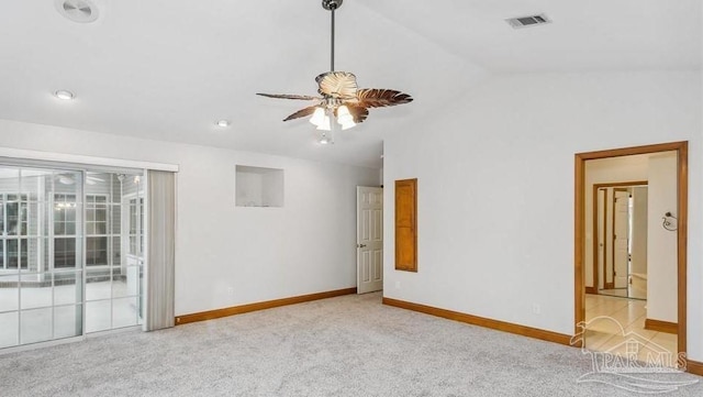 carpeted spare room with ceiling fan and vaulted ceiling