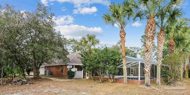 view of front of home featuring a lanai, central AC, and a swimming pool