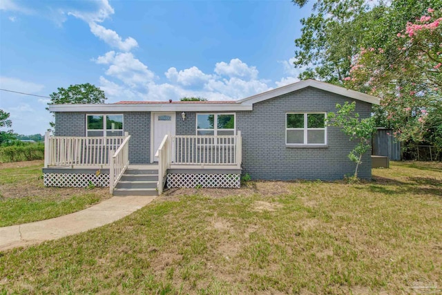 2511 Green Village Rd, Walnut Hill, FL 32568 - view of front of house with a wooden deck, brick siding, and a front lawn