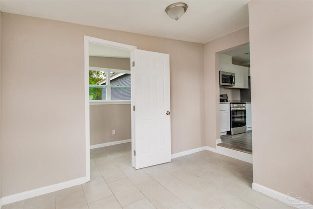 2511 Green Village Rd, Walnut Hill, FL 32568 - empty room with light tile patterned floors and baseboards