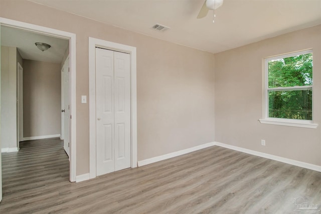 2511 Green Village Rd, Walnut Hill, FL 32568 - unfurnished bedroom featuring wood finished floors, visible vents, baseboards, ceiling fan, and a closet