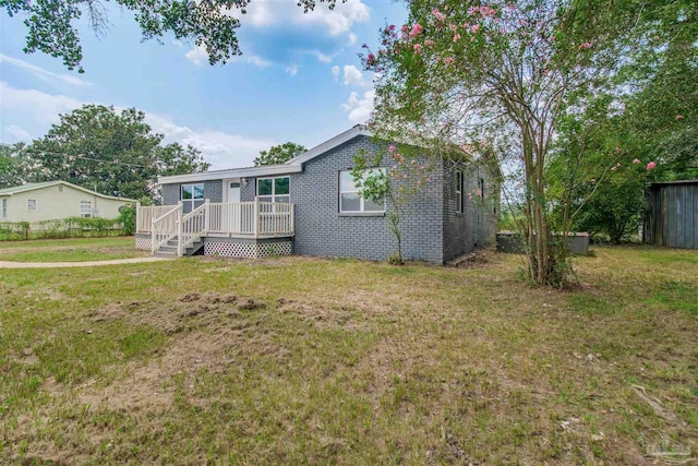 2511 Green Village Rd, Walnut Hill, FL 32568 - exterior space featuring brick siding, a deck, a yard, and fence
