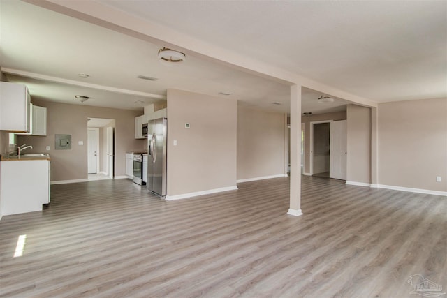 2511 Green Village Rd, Walnut Hill, FL 32568 - unfurnished living room featuring a sink, baseboards, and light wood finished floors