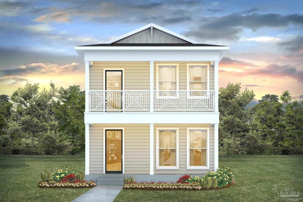 view of front of property with board and batten siding, a front yard, and a balcony