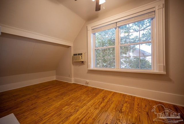 bonus room featuring a wall mounted AC, hardwood / wood-style flooring, vaulted ceiling, and ceiling fan