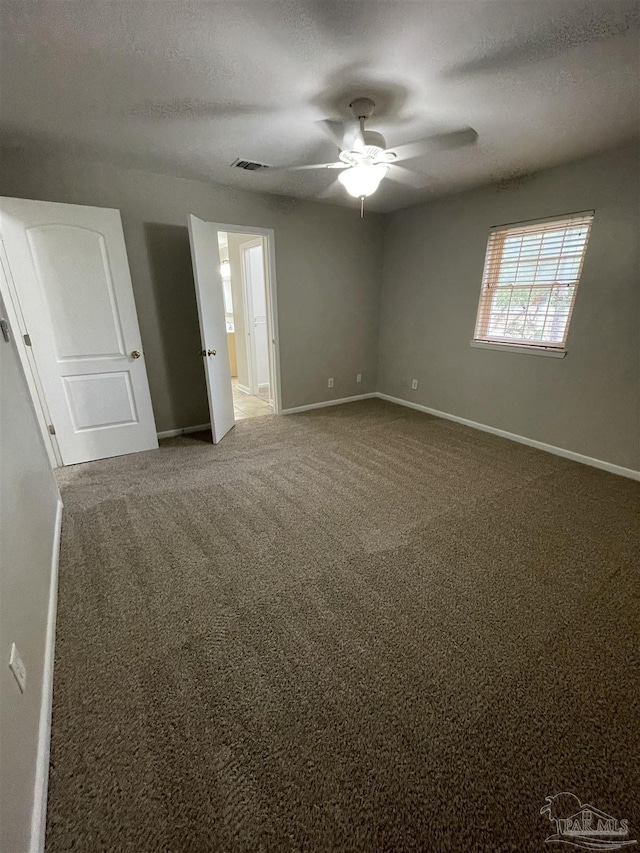 unfurnished bedroom featuring baseboards, carpet, ceiling fan, and a textured ceiling