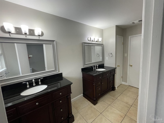 full bathroom featuring tile patterned floors, two vanities, and baseboards