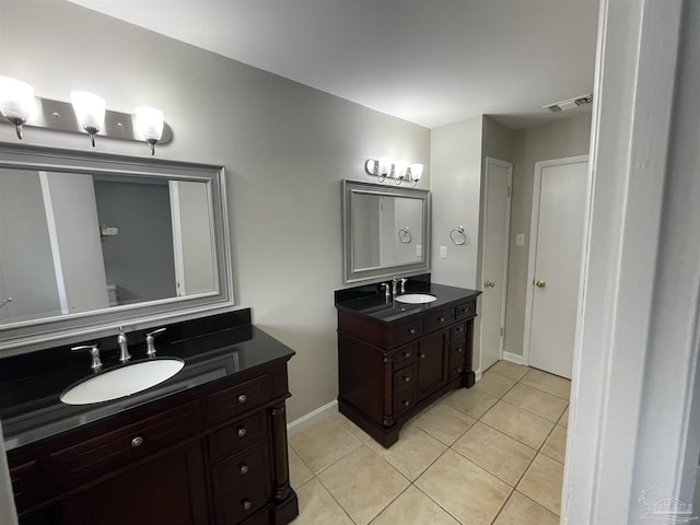 bathroom with tile patterned floors, two vanities, and baseboards