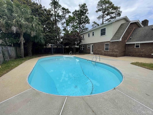 view of swimming pool with a patio, a fenced backyard, and a pergola